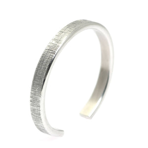 1 of 7: A Thin Linen Aluminum Cuff Bracelet on a White Background