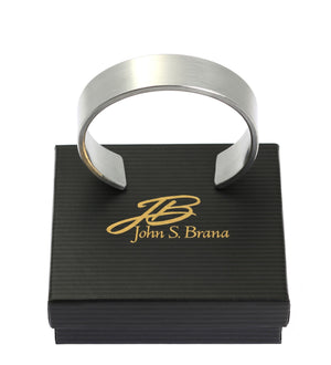 6 of 7: 19mm Brushed Aluminum Cuff Bracelet on top of a Black Gift Box with Gold Logo