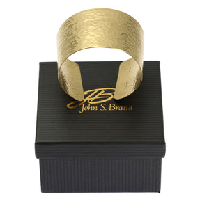 7 of 8: Hammered Nu Gold Brass Cuff on Top of a Black Gift Box with Gold Logo