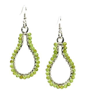 1 of 4: A Pair of Hammered Silver Drop Earrings with Peridot on a White Background