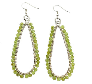 1 of 4: A Pair of Hammered Silver Teardrop Earrings with Peridot on a White Background